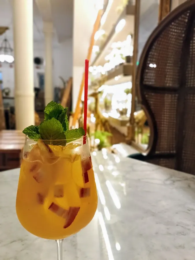 A mango cocktail with fresh mint and a red straw